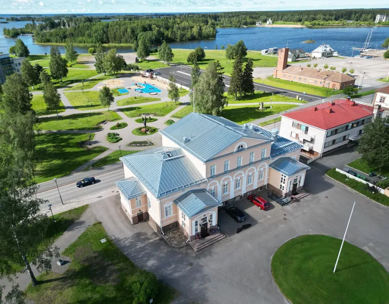 Raahen raatihuoneen uusi tuplasaumakatto ilmasta, taustalla leikkipuisto ja meri