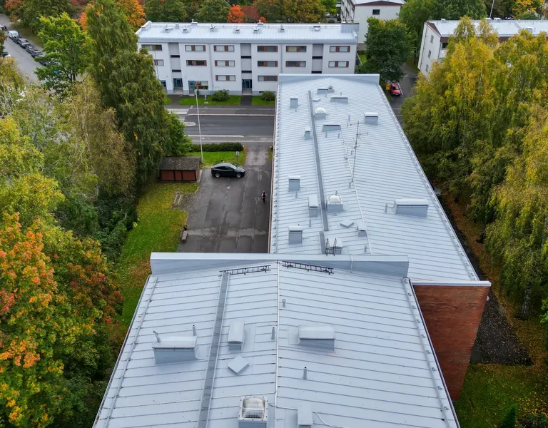 As Oy Siltavoudintie 10:n uusi vaaleanharmaa konesaumakatto ilmasta, kattoluukut ja turvatikkaat näkyvissä